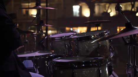 slow rotating shot of a drummer playing his drums on stage at a festival