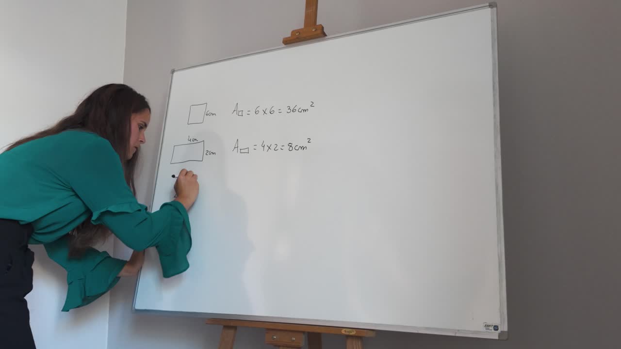 mujer enseña fórmulas de geometría en una pizarra en un entorno de clase