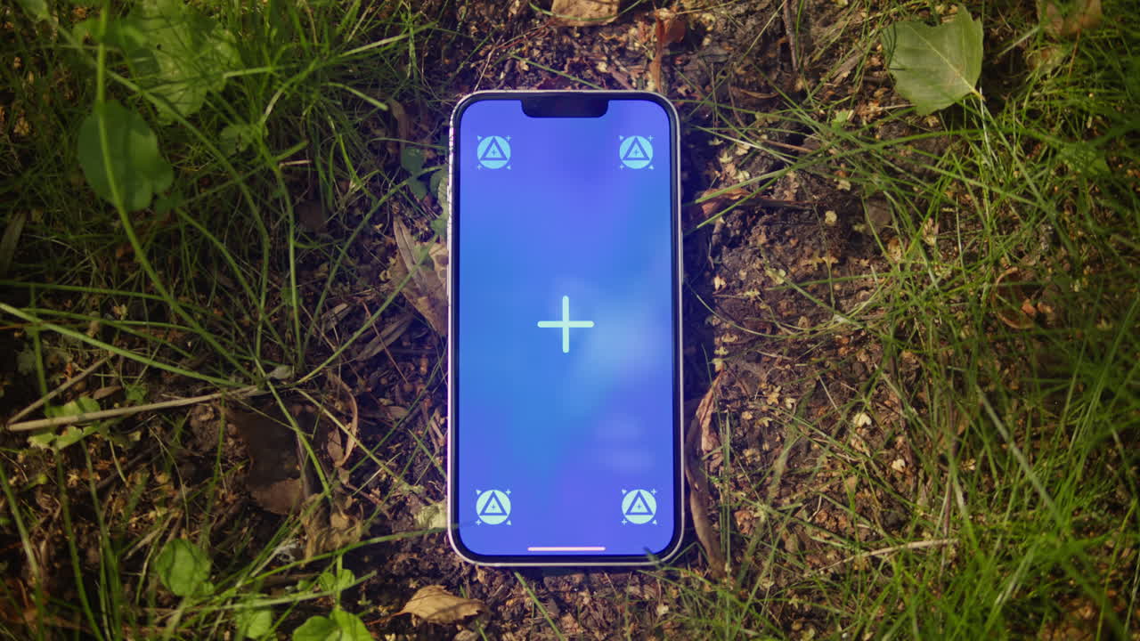 Phone with chroma key screen on the earth ground close-up. Green screen on smart phone. Nature