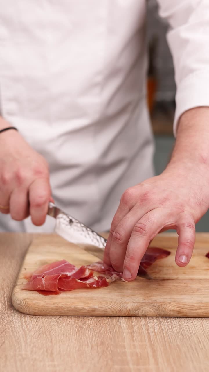 el chef está cortando el prosciutto.