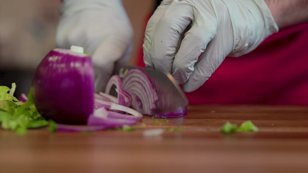 A chef carefully slices a fresh onion on a cutting board, highlighting clean knife work, vibrant color, and culinary prep in a professional kitchen