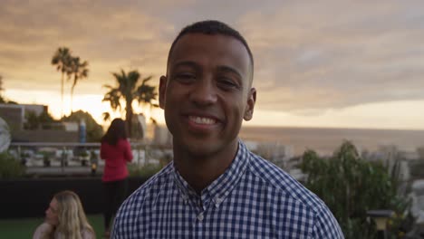 Young-African-American-man-smiling-at-camera-on-a-rooftop