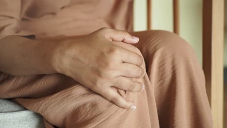 close up of a woman's hand resting on her leg