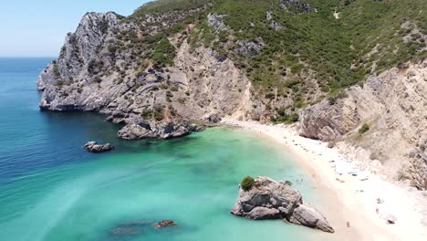 Playa-De-Praia-Ribeira-Do-Cava-Cerca-De-Sesimbra,-Alentejo,-Portugal---Vista-Aérea-De-Drones-Volando-Hacia-La-Playa-De-Arena-Y-El-Mar-Turquesa