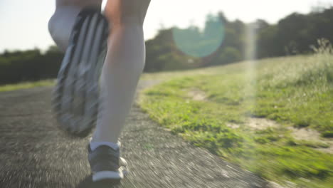 一位年輕女子的腿在日落時跑在軌道上