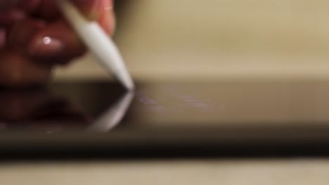 hand using a stylus on a tablet