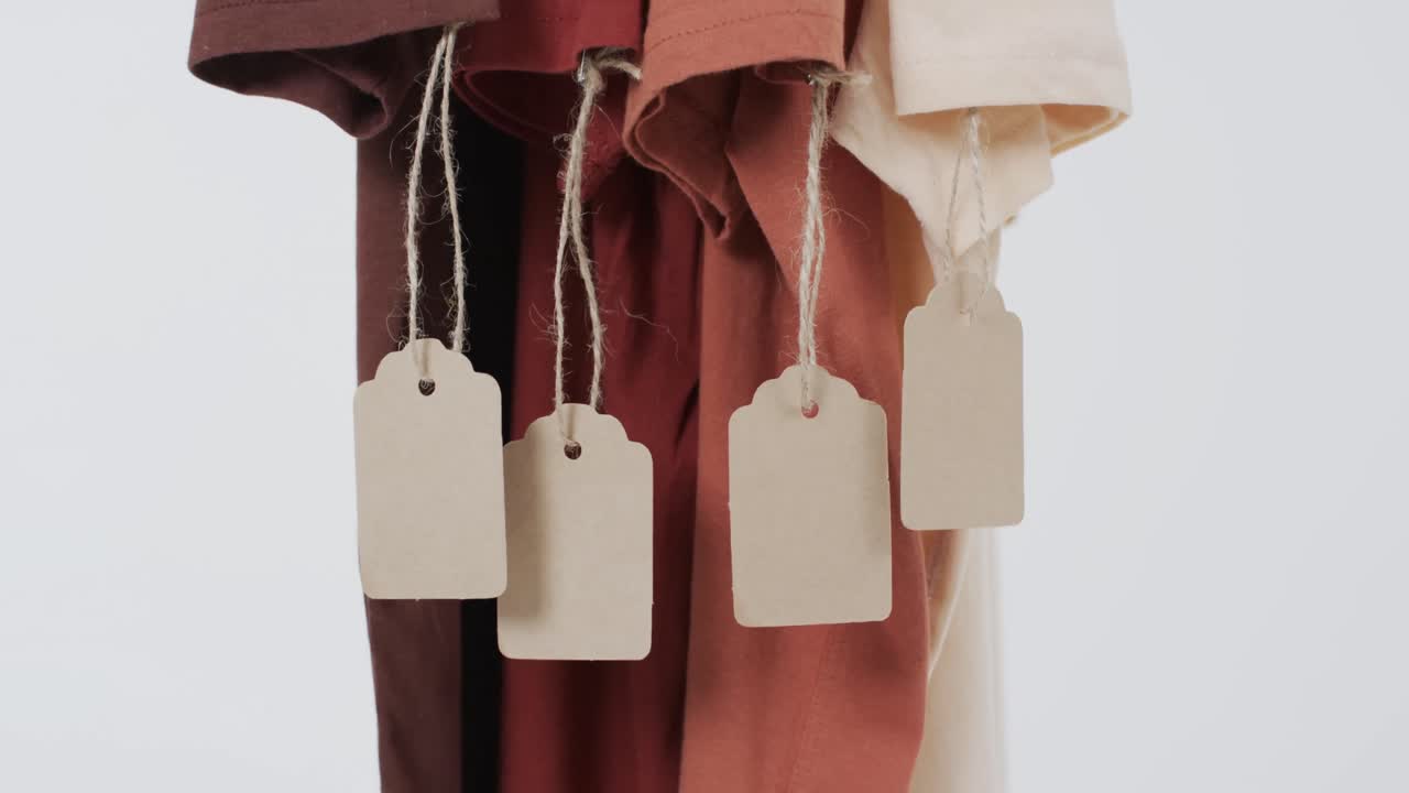 ⁇ 색 배경에 태그와 복사 공간을 가진 네 개의 t 셔츠의 비디오