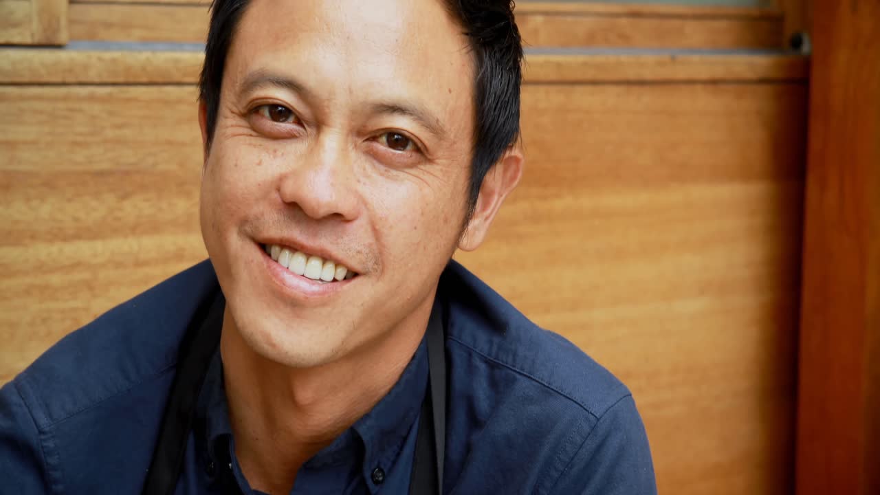 야외 카페 4k에서 카메라를 보는 웨이터