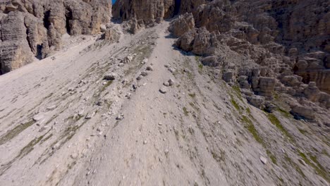 FPV-drone-flying-close-of-the-limestone-rock-wall-revealing-the-famous-Tre-Cime-di-Lavaredo-mountain-at-Dolomites,-Veneto-region,-Italian-Alps