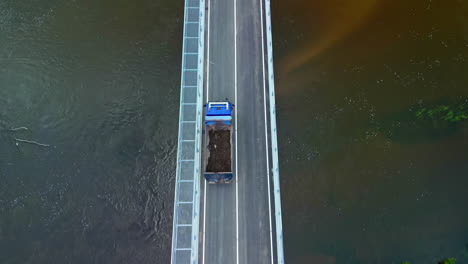 truck crossing a bridge over a river - straight down aerial view