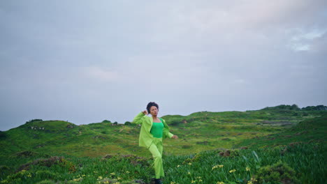 Stylish-girl-dancer-performing-modern-dance-on-field-under-gray-sky-vertically