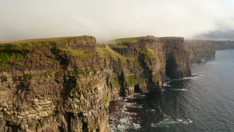 Fly-above-sea-at-coast.-High-rocky-cliffs-above-rippled-water.-Breath-taking-panoramic-natural-scenery.-Cliffs-of-Moher,-Ireland