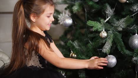 little girl decorating christmas tree