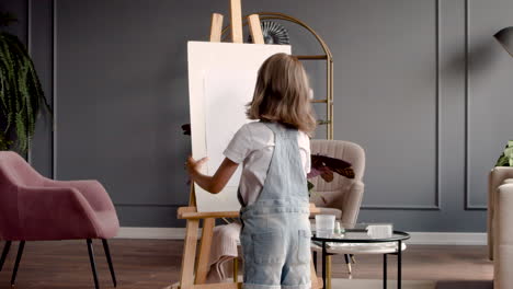 rear view of a girl looking at her drawn plant on a lectern in the living room at home