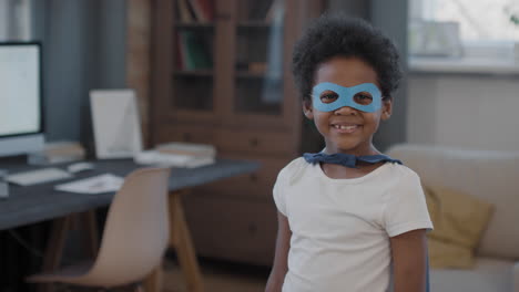 portrait of mixed-race boy in superhero mask