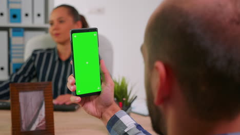 manager in wheelchair using greenscreen smartphone