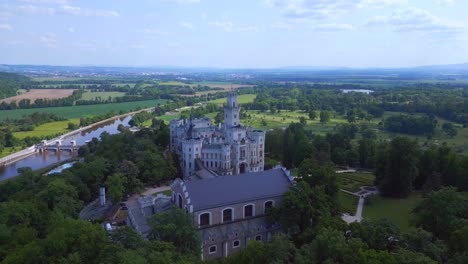 river in valley, smooth aerial top view flight fairy tale castle in czech republic europe, summer day 2023