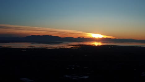 gorgeous aerial drone view of utah lake during a golden sunset on a warm fall evening in provo