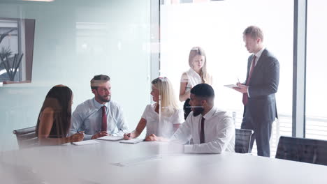 grupo que colabora en una tarea en el día de evaluación de la contratación de graduados mientras es observado por el equipo de contratación