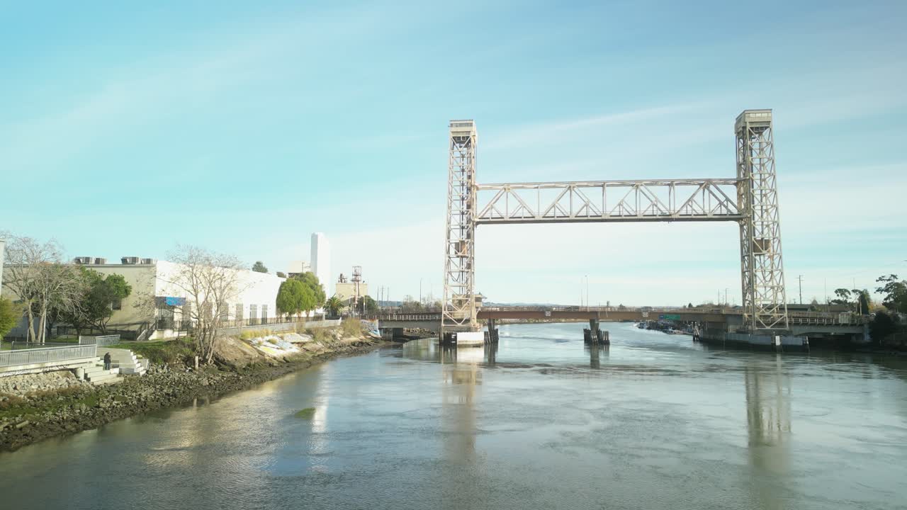 Aerial drone view displays the Miller Sweeney Bridge in Alameda, showcasing its structure and the flowing water below.