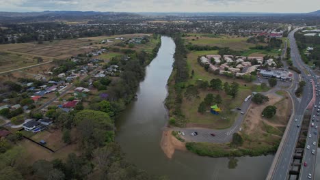 aerial pullback above logan river in the town of waterford in logan city, queensland, australia