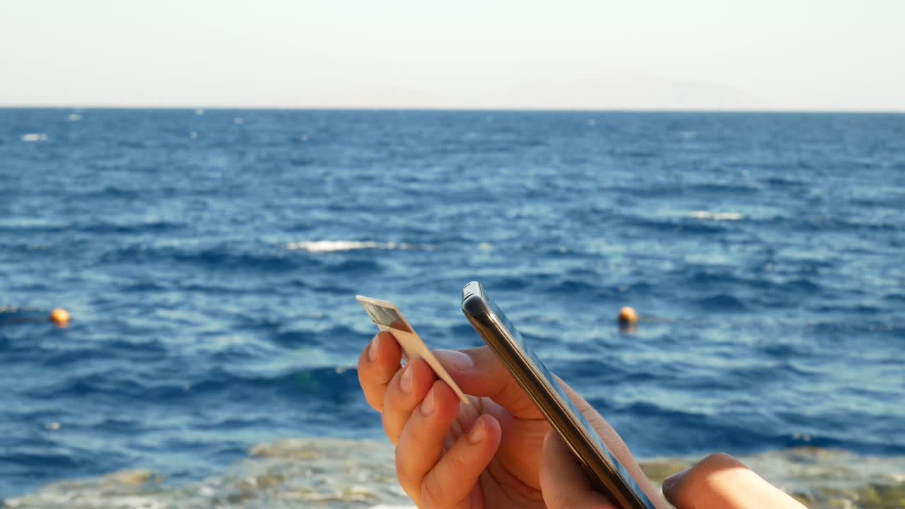 신용카드를 들고 휴대전화로 온라인에서 쇼핑하는 남자