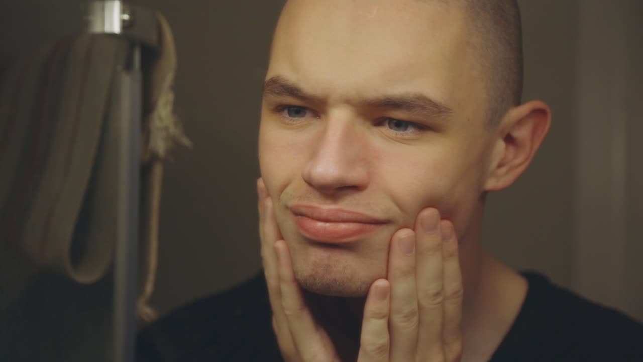 Handsome Young Man Standing In Front Of Mirror Touching Face With His Fingers - Closeup Shot