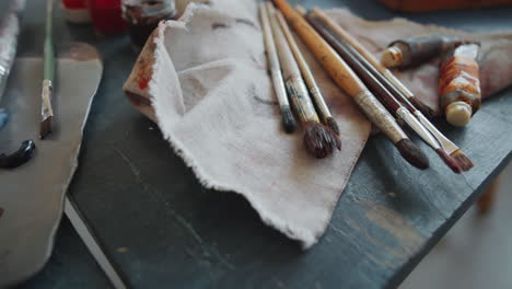 artist's workspace with paintbrushes and palette