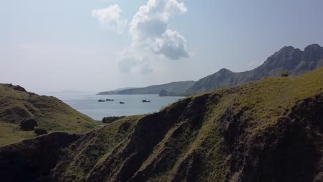 aerial of dense green mountains at the coastline of beautiful blue ocean