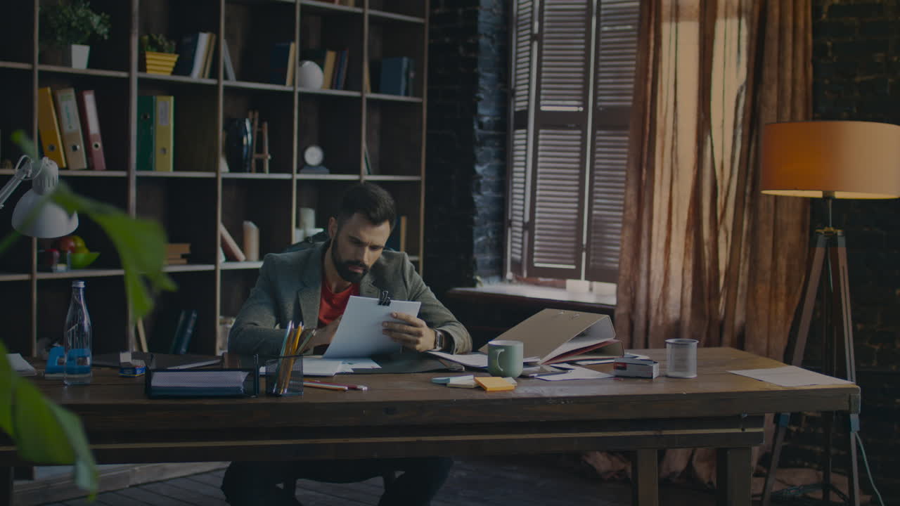 Young businessman working with paper documents. Creative office work