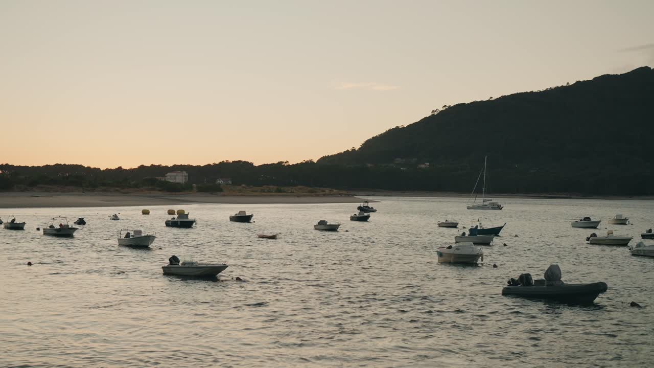 Small boats floating on water at sunset in Moledo do Minho Portugal