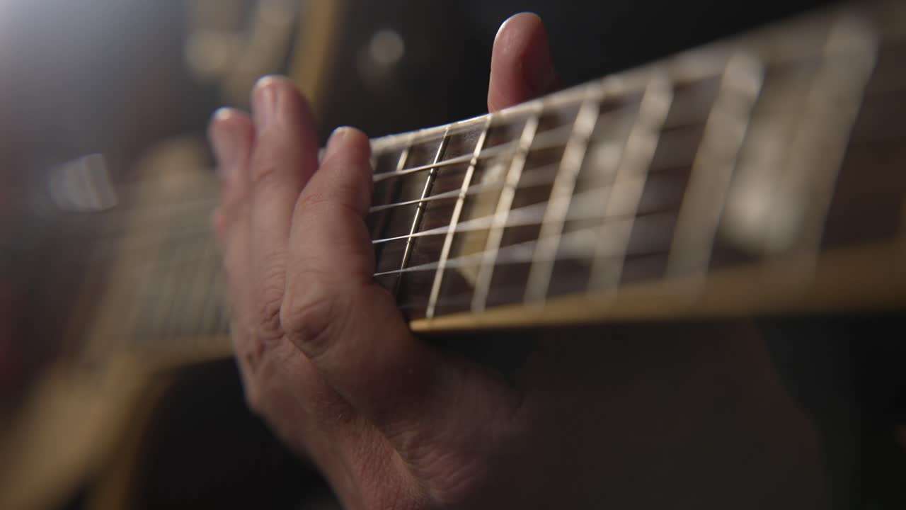 Extreme Close Up Of Guitar Players Hand On Guitar Neck While Playing