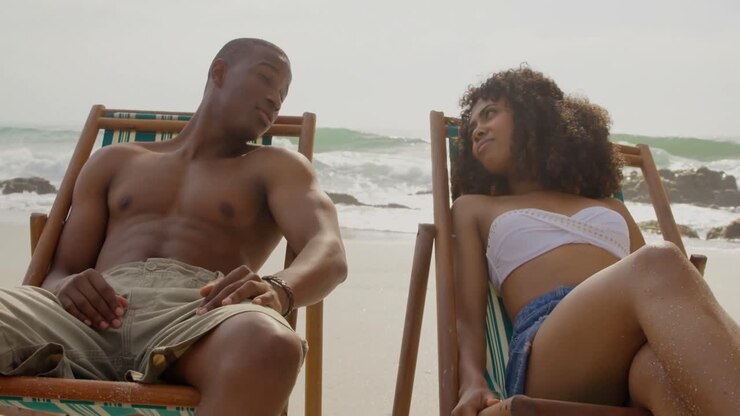 Vista frontale di una coppia afroamericana insieme in spiaggia 4k