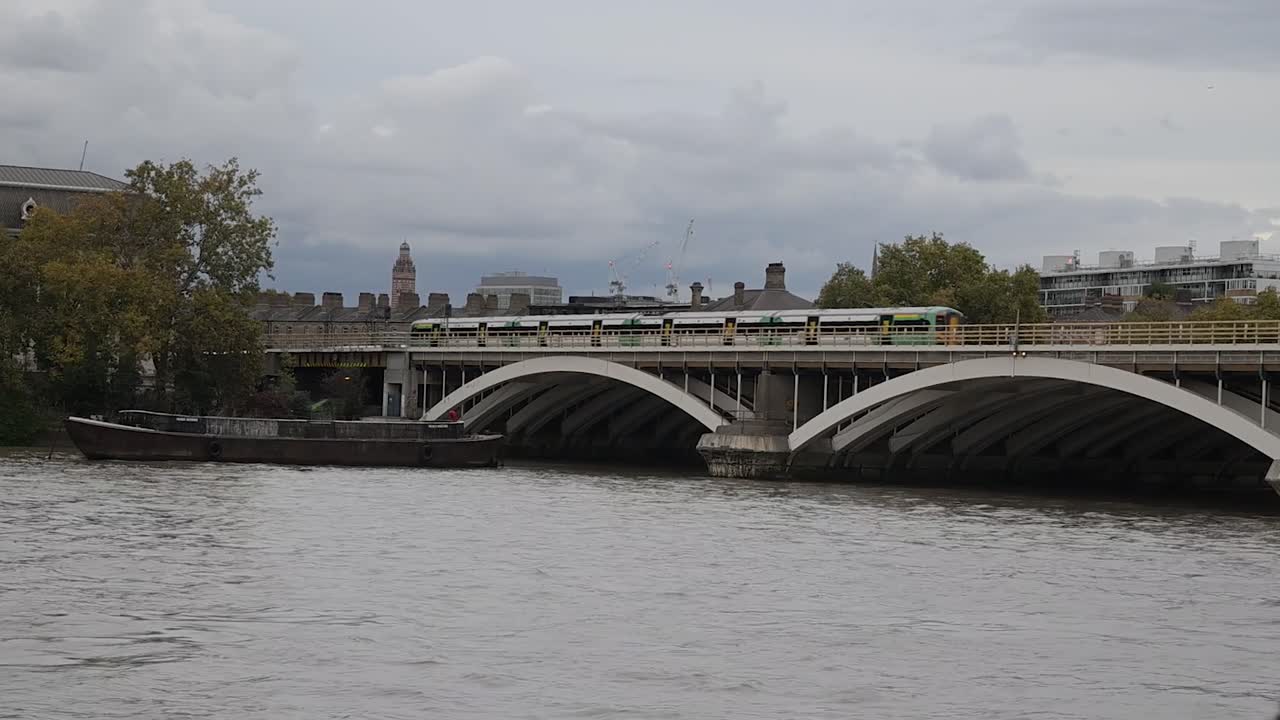 A Southern Railway train crosses the River Thames heading towards Victoria Station, showcasing London’s rail infrastructure and scenic riverside views