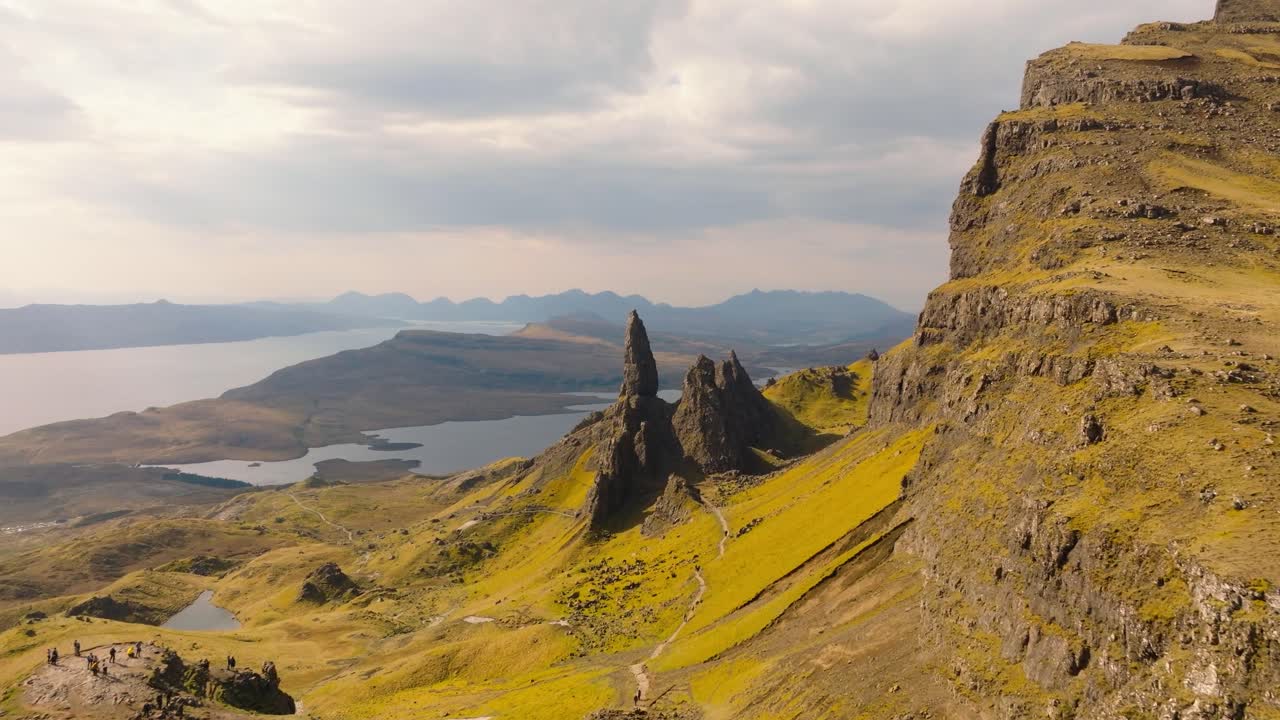 Aerial drone footage of the dramatic mountain landscapes and Old man of Storr on the Isle of Skye, Scotland. Sweeping panoramic views of majestic peaks, green valleys, and wild nature
