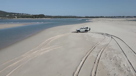 low aerial orbits truck parked on noosa heads sand beach in australia