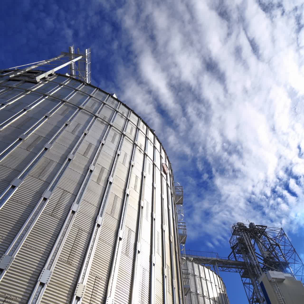Grain elevator. Large steel granary for processing agricultural products. Hangar premises outdoors. View from below.