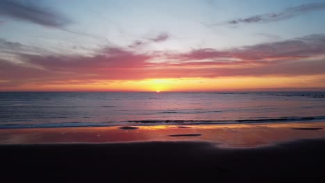 el sol deslumbrante que se pone más allá del lejano horizonte, proyectando un caloroso resplandor en el tranquilo paisaje