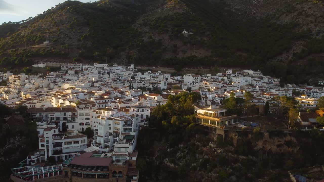 Hvide bygninger og solnedgangens skær over byen Mijas, luftfoto