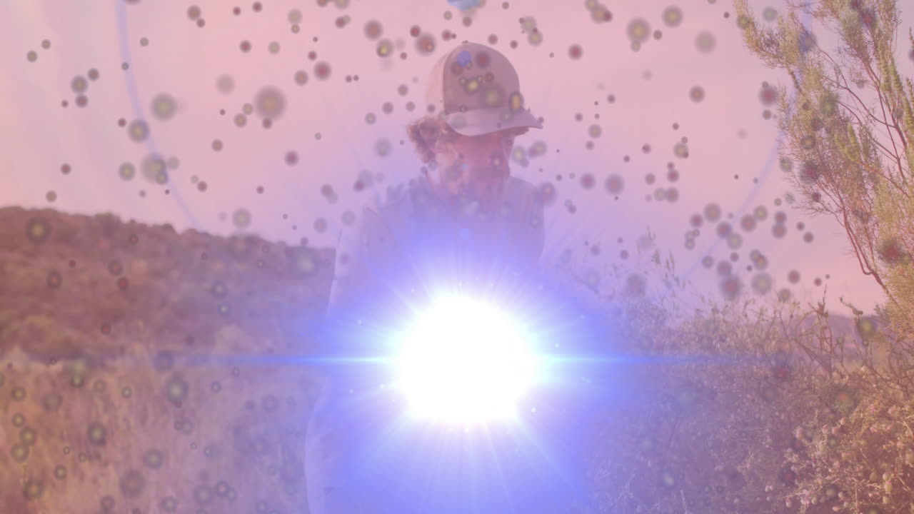 Helmeted technician emitting bright blue-white beam in desert technology demo, creating lens flare