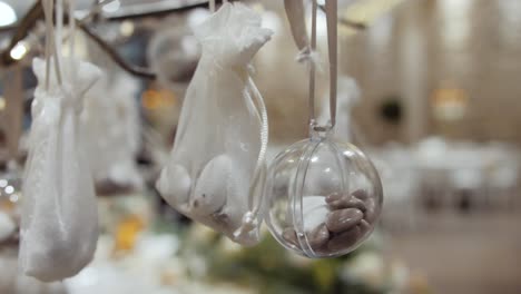 slow dolly shot of rocks in white bags and baubles at a wedding