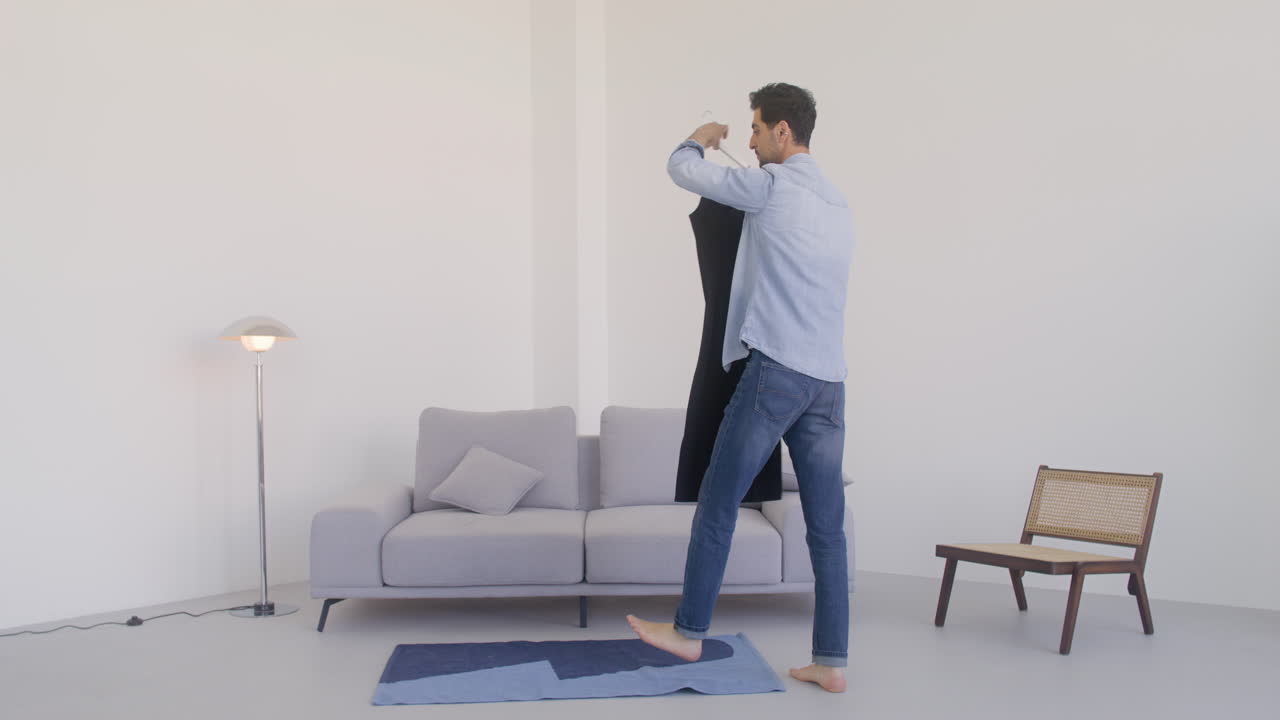 검은 머리 남자가 방에서 검은 드레스를 입고 춤을 춘다