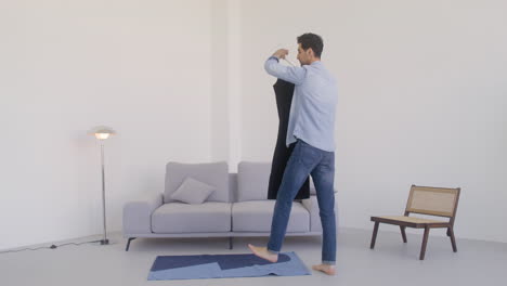 A-Dark-Haired-Man-Dances-With-A-Black-Dress-In-A-Room