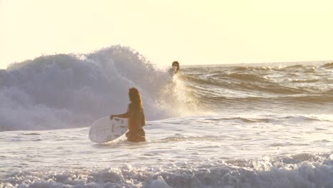 surfeur tombant de sa planche au coucher du soleil