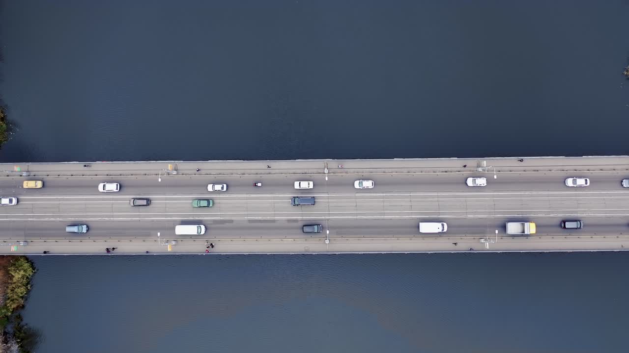 Pedestrians and cars move across the bridge in the city. View from the top. Aerial view