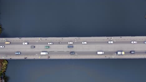 pedestrians and cars move across the bridge in the city. view from the top. aerial view