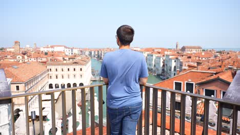 Man-on-Fondaco-dei-Tedeschi-terrace-overlooking-Venetian-Grand-Canal,-Italy