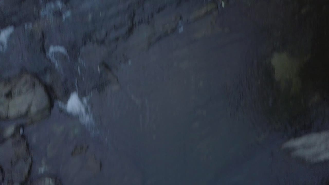 Quick flight above rocks and waterfall into Amazon rainforest