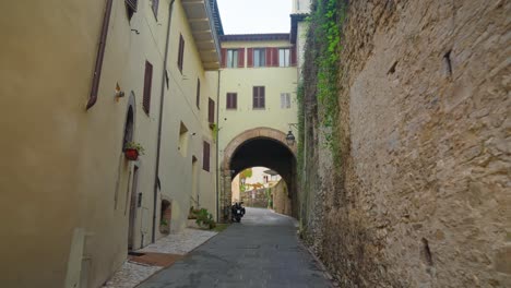 walking on typical arched street alleys of spoleto, province of perugia, umbria in italy