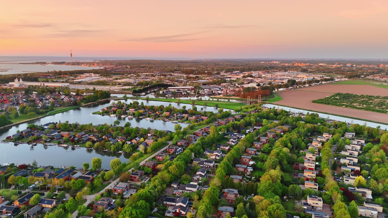 Canals at sunset, Netherlands. A golden sunset lights up the canals and homes in a Dutch residential area, blending nature and architecture